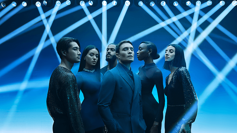 Ed Westwick and dancers under blue stage lights